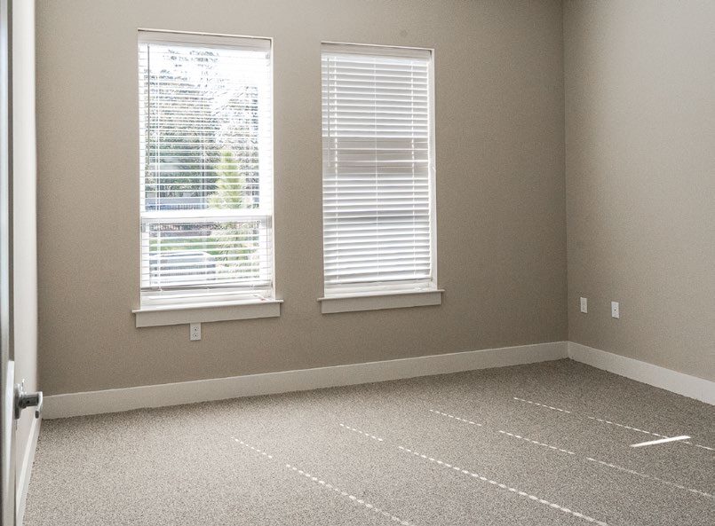 An apartment bedroom with new carpet and fresh wall paint. 