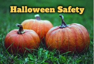 Three pumpkins sitting on the grass with text that reads: Halloween Safety.