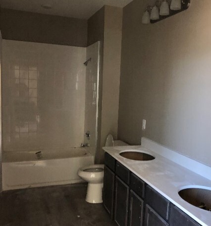 Unfinished bathroom with a dual sink and shower. 