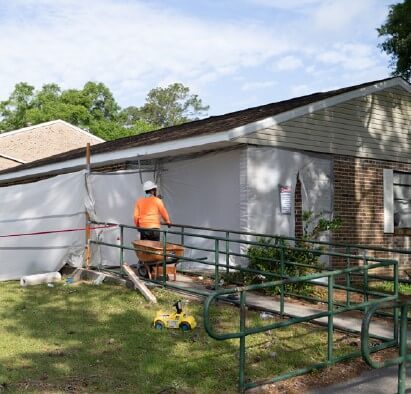 A construction worker working on the side of a house