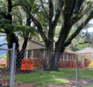 Country Club Drive is surrounded by a large chain link fence.