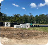 Large storm drainage pipes are waiting to be installed.