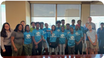 The children in the Boys and Girls Club program all stand together and smile brightly.