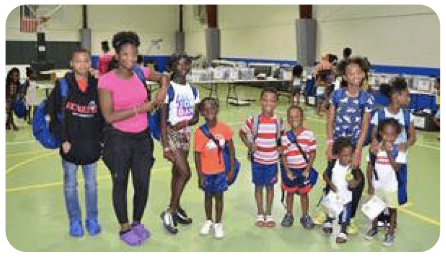 A group of children and adults standing in a gymnasium