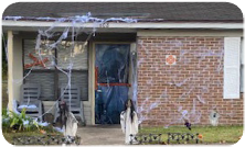 Fake cobwebs cover the brick and ghosts line the yard of a Pinewood Place residence..