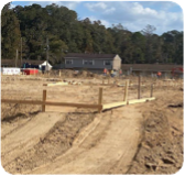 A large empty hole in the ground is slowing filling up with water. 