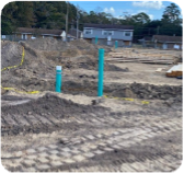 A large tractor is digging into the ground to do drain line installation.