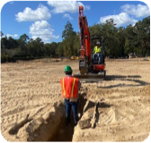 Large storm drainage pipes are being placed into the ground.