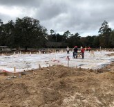 The foundation of Building 2 being inspected by a group of workers.