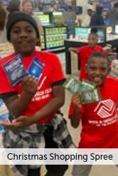Christmas Shopping Spree. Two children smile while holding up cards.