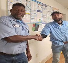 Two men shake hands.