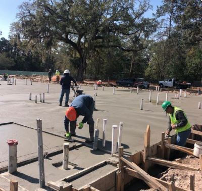 Several men smoothing recently poured concrete.