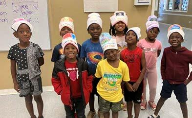 Group of boys and girls wearing homemade hats.