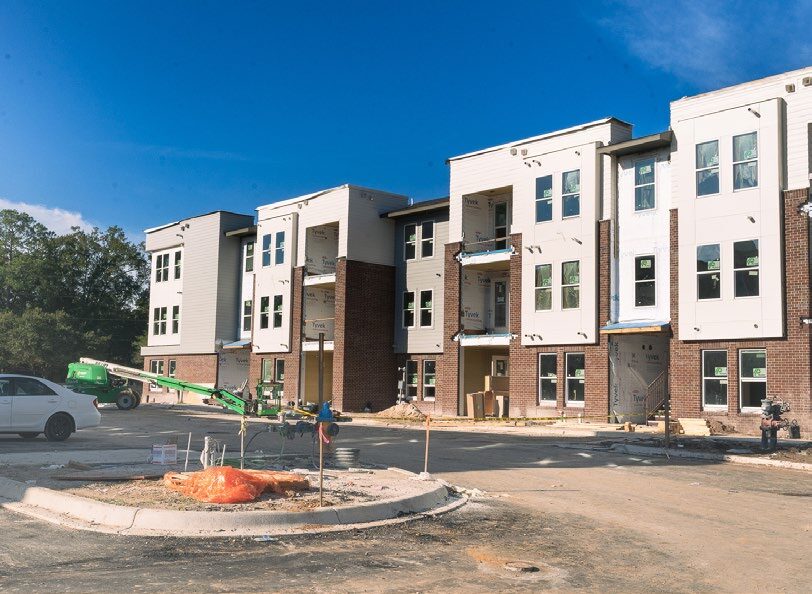 The exterior of an appartment complex on a sunny day. 