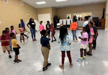 Children in a circle, standing and facing each other. 