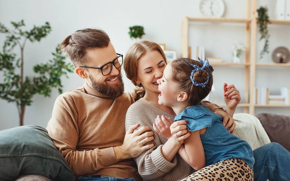 Family laughing on a couch. 