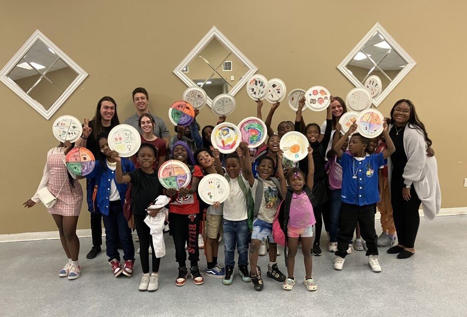 Children holding up decorated circles.