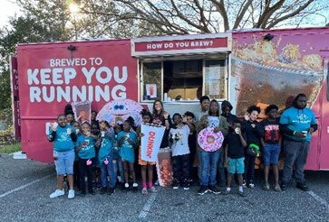 Group standing in front of a Dunkin food truck. 