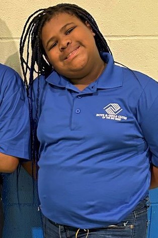 Young woman smiling wearing a Boys and Girls Clubs Shirt.