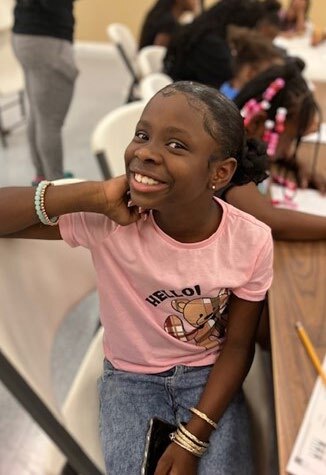 Young girl smiling wearing bracelets. 