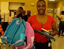A woman holding up two backpacks.