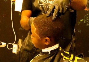 A child getting his fair done by a barber.
