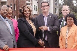 Executive Director, Brenda Williams cutting a red ribbon.