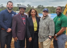 Executive Director, Brenda Williams, standing and smiling with four men for a photo.