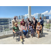 A group of people posing on the balcony with a city view in the background