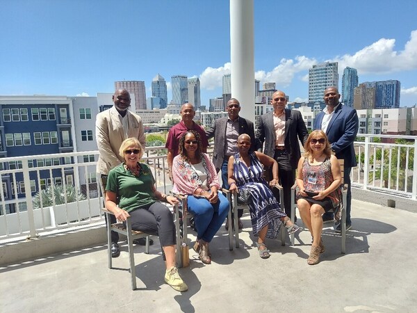 TAHAFLAgroupposingonthebalconyinfrontoftheCityview.jpg A group of people posing on the balcony with a city view in the background