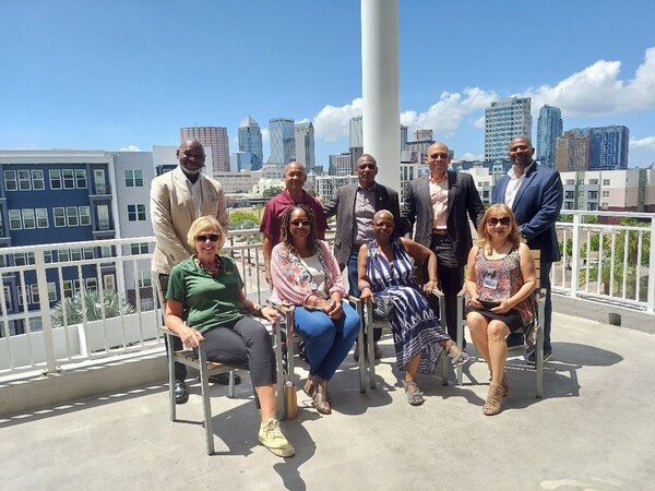 A group of people posing on the balcony with a city view in the background