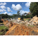 A tractor works at removing an old building slab.