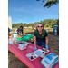 A woman looks up and smiles while she puts together a Styrofoam container of  breakfast food. 