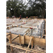 A construction worker working on the stakes and foundation of Building 4 on Orange Ave.