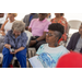 A woman is listening intently to a speaker.