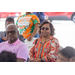 A woman wearing sunglasses listens to a speaker.