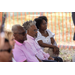 A woman and two men listen to the speaker.