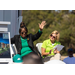 Woman raising her hands while another woman looks on. 