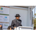 Man in a hat speaks to the audience. 