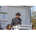 Well-dressed man speaking from the podium in a hat. 