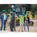 Peope lined up to begin first shovel in hard hats. 