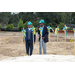 Two men with shovels and hard hats speaking to the audience. 