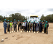 Team with shovels and hard hats pose for photo. 