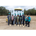 Eight people with shovels pose for photo. 