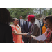 A man with a bright red hat shaking hands with Marcia Fudge.