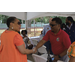 A man with a red shirt shaking hands with Marcia Fudge.