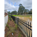 A view of a fence with a pond on the other side.