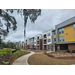 A view of a long sidewalk leading up to apartments. 