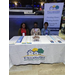 Three people from Tallahassee Housing Authority sitting at a tradeshow table with handouts and liturature on the table. 