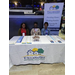 Three people from Tallahassee Housing Authority sitting at a tradeshow table with handouts and literature on the table. 
